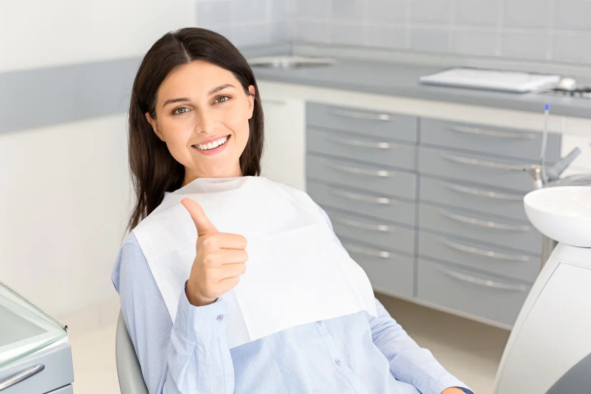 This image captures a dental procedure where professionals are attending to a patient using specialized tools and safety equipment, ensuring a thorough and safe treatment experience.